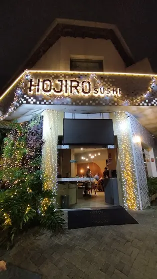 Fachada iluminada do Hojiro Sushi à noite